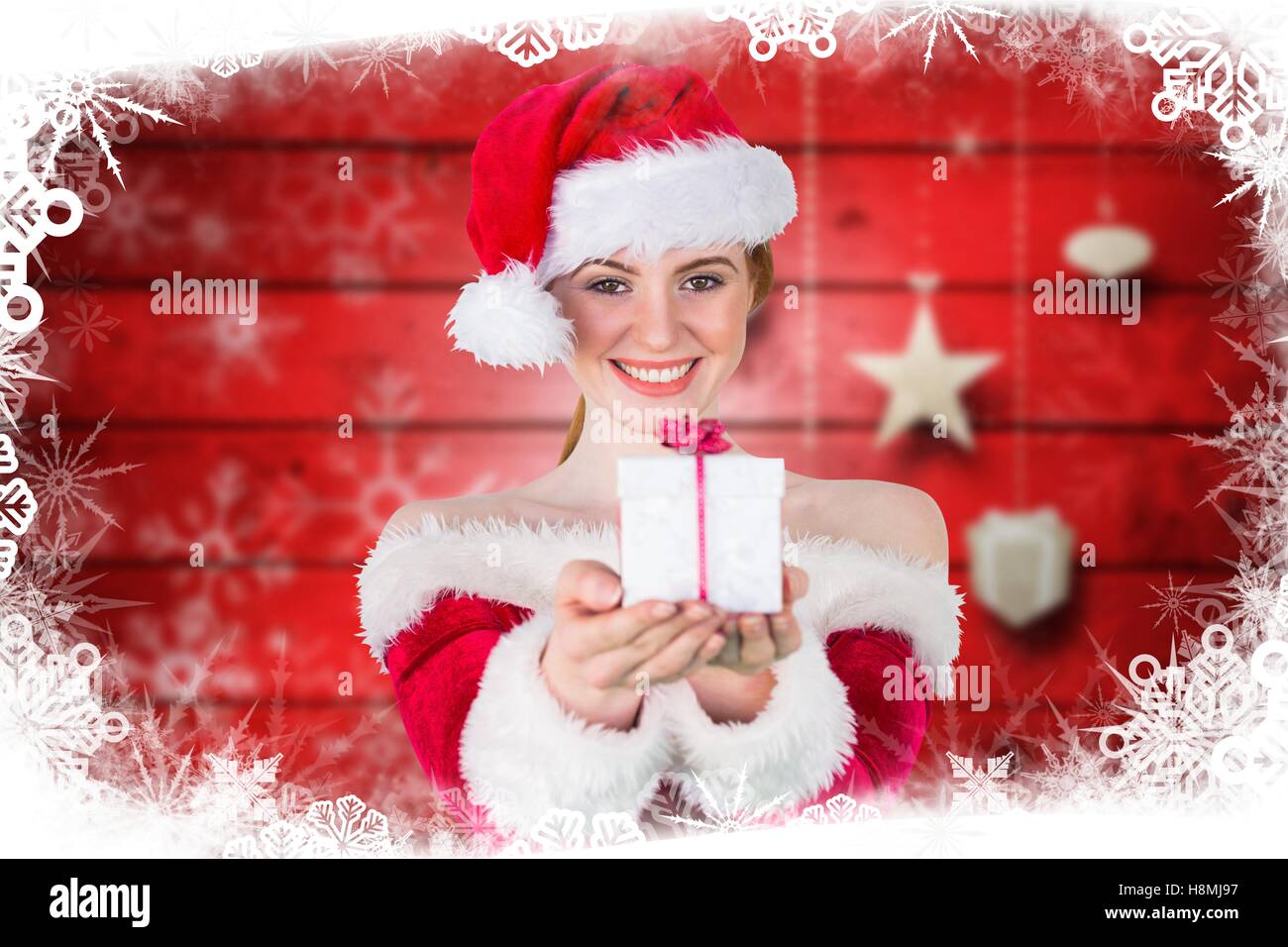 Belle femme en costume père noël offrant un cadeau de Noël Banque D'Images