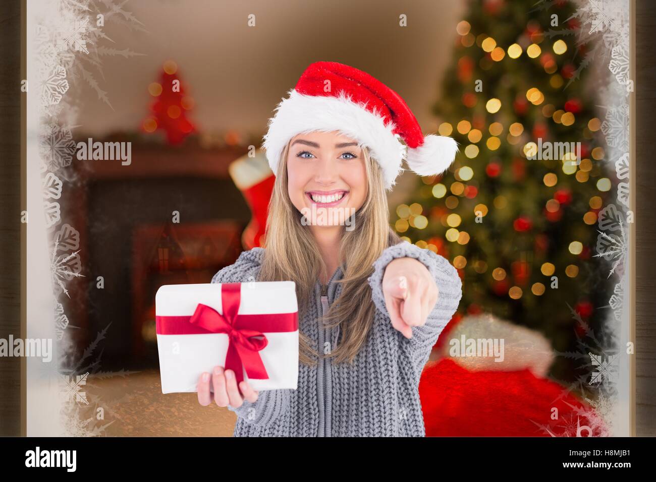 Beautiful woman in santa hat holding a Christmas Gift Banque D'Images