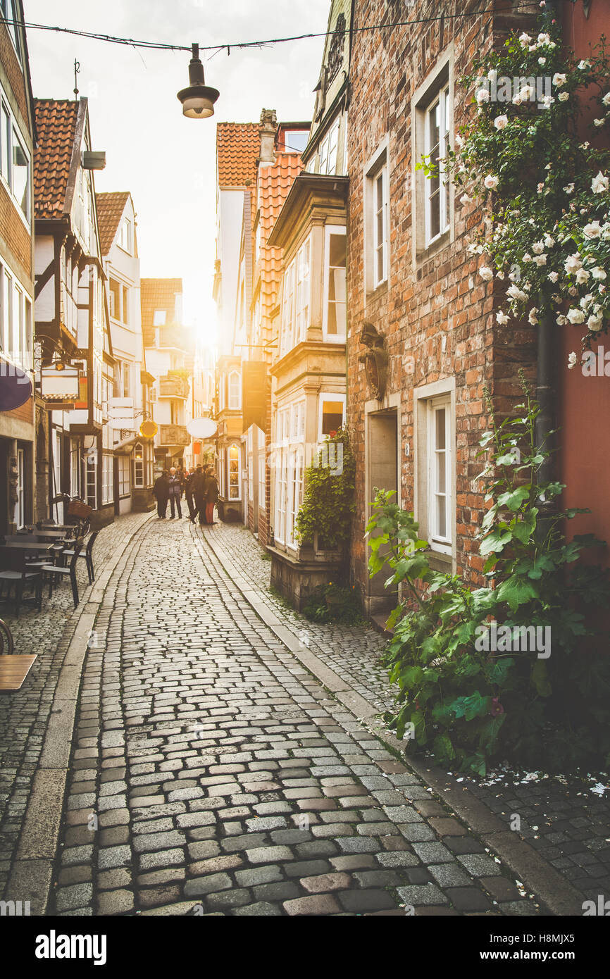 Scène de rue enchanteresse dans une ancienne ville d'Europe au coucher du soleil avec des tons pastel vintage rétro et lens flare filtre effet de soleil Banque D'Images