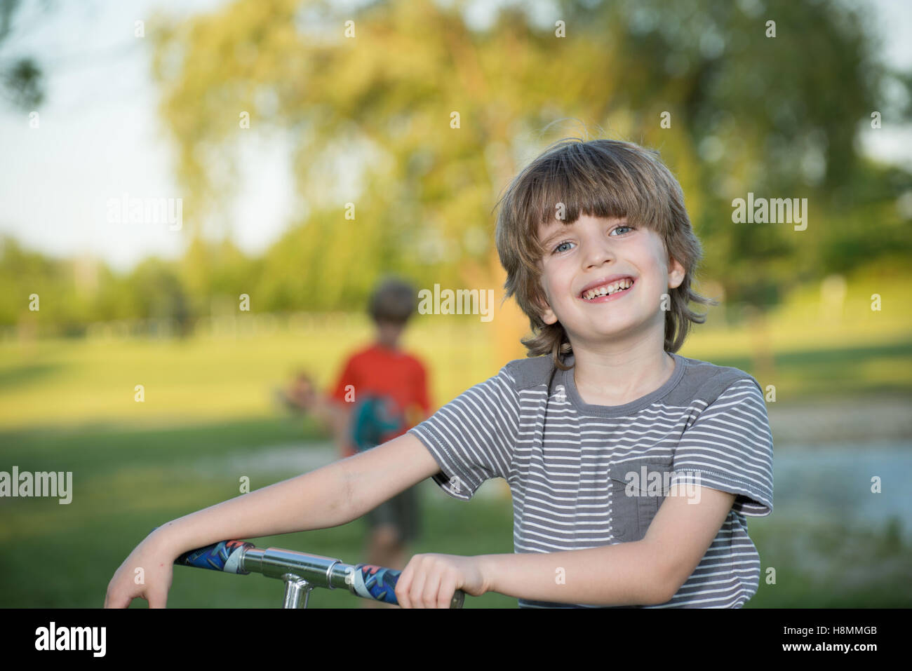 Portrait d'un jeune garçon dans un parc avec arrière-plan flou Banque D'Images