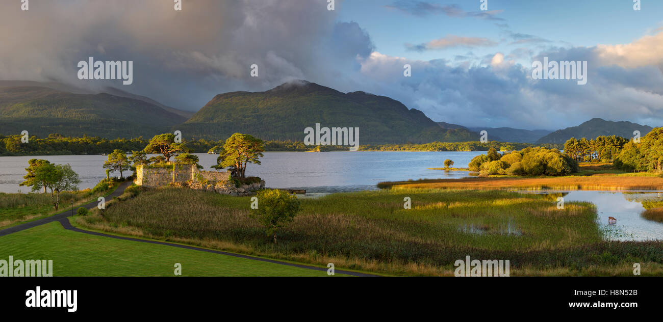 Aube sur McCarthy Mor château le long de Lough Leane, le Parc National de Killarney, comté de Kerry, Irlande Banque D'Images