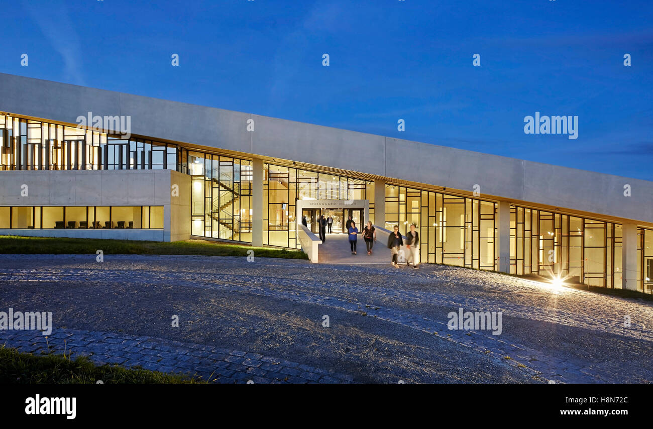 Entrée principale avec l'intérieur éclairé la nuit. Musée Moesgaard, Aarhus, Danemark. Architecte : Henning Larsen, 2015. Banque D'Images