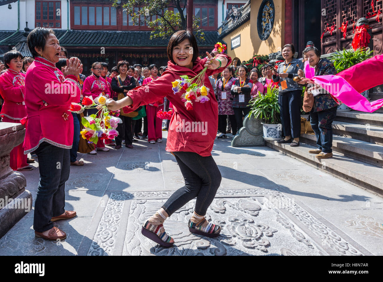 Chinese woman dancing avec des fleurs près du Temple du Bouddha de Jade à Shanghai, Chine Banque D'Images