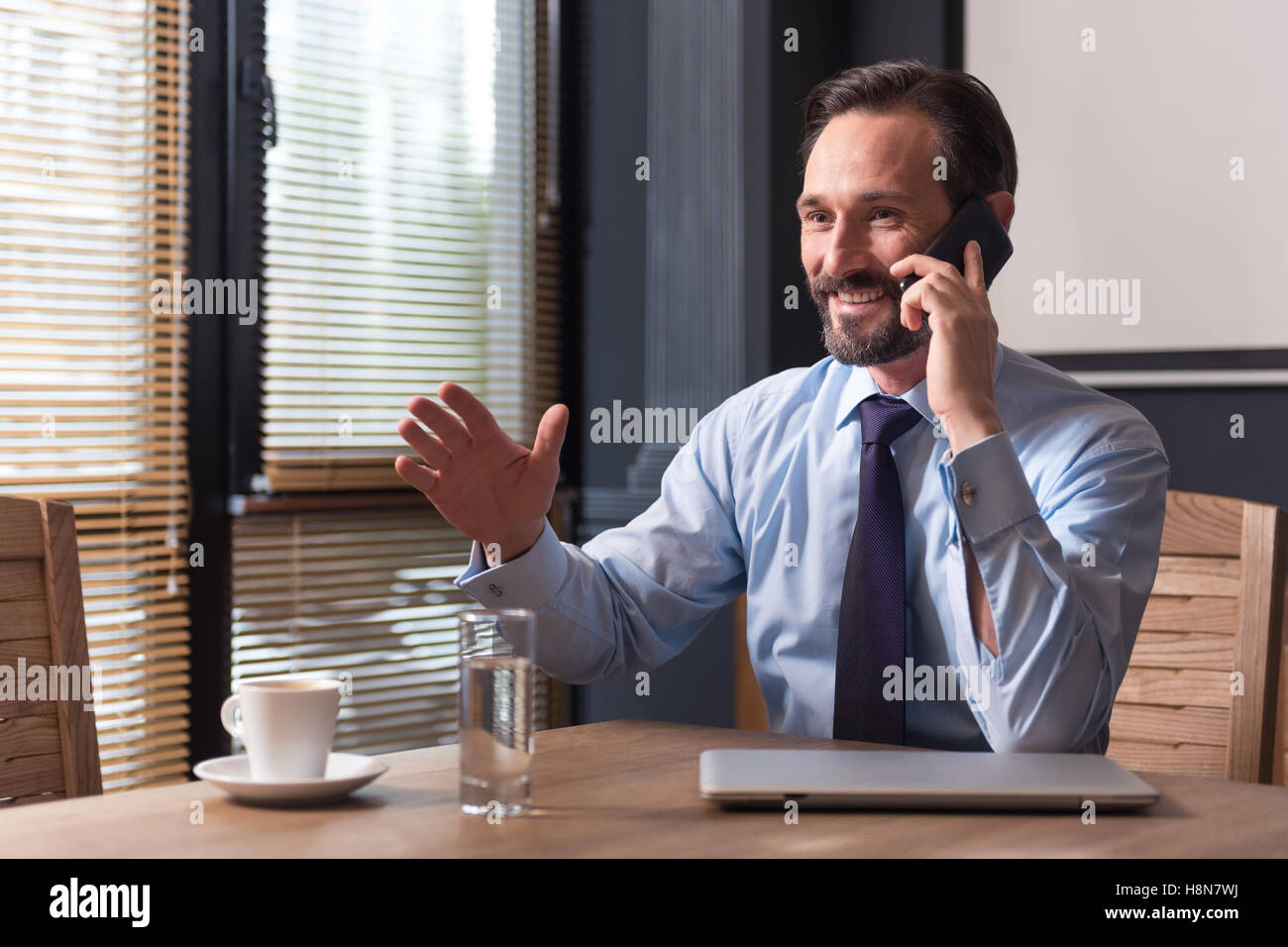 Homme confiant positif d'avoir une conversation au téléphone Banque D'Images