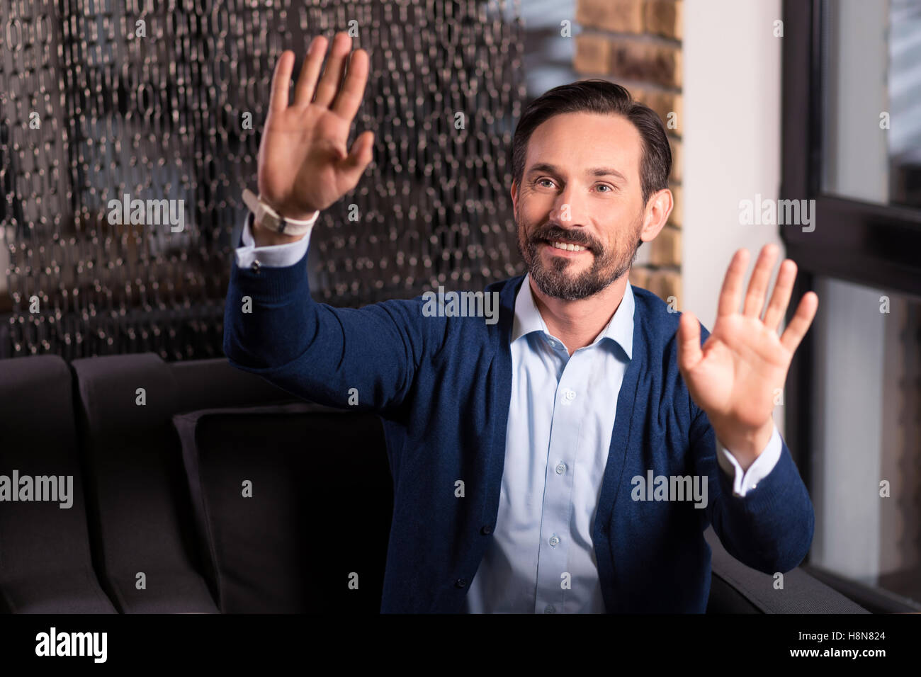 Heureux homme barbu en appuyant sur ses paumes à l'écran virtuel Banque D'Images