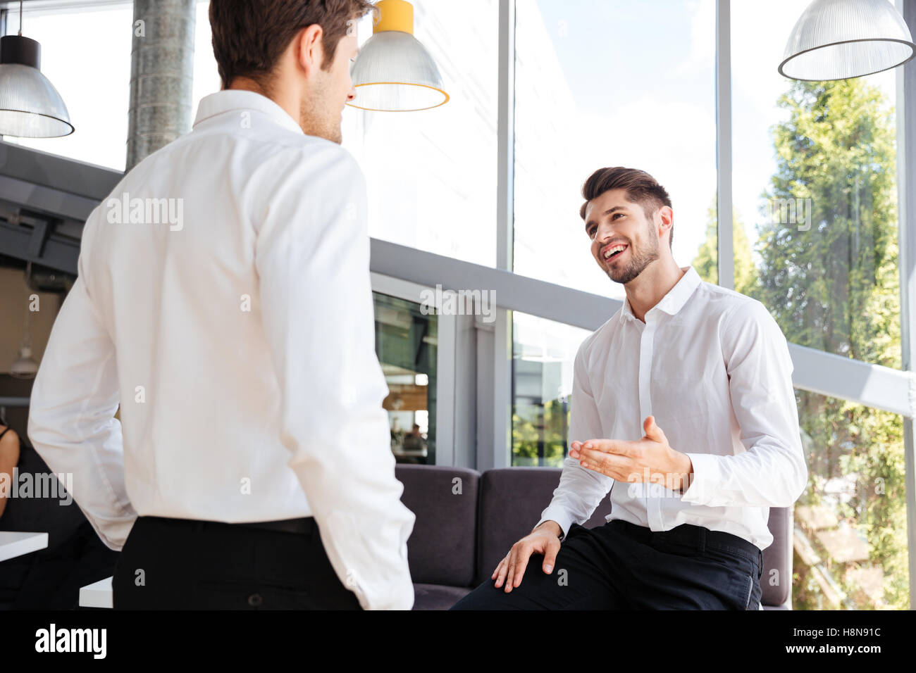 Deux jeunes hommes d'smiling relaxed standing in office Banque D'Images