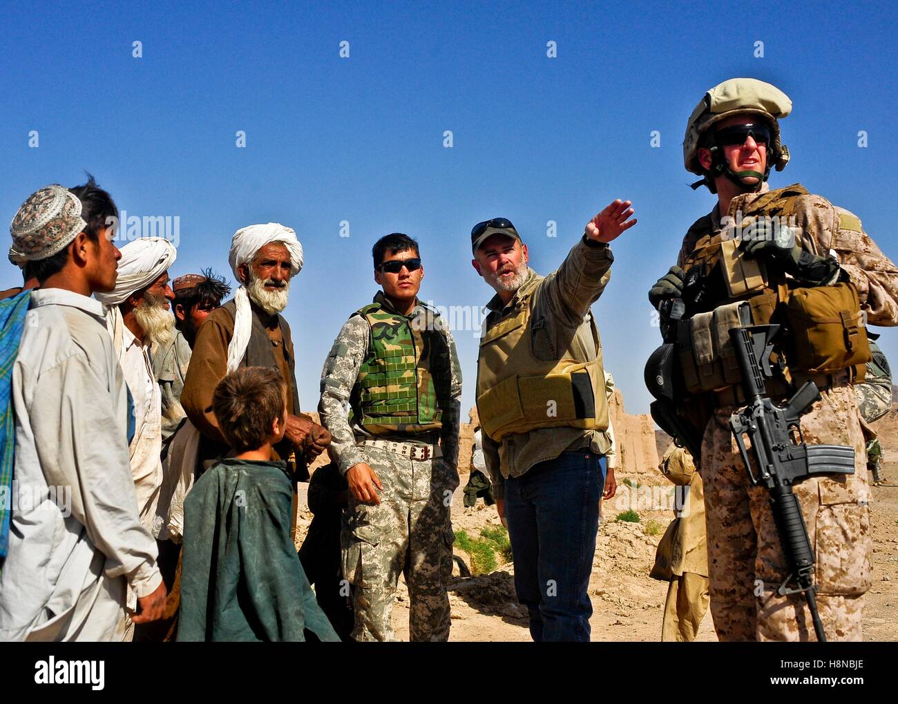 Des soldats afghans et des Marines de la tribu Kuchi gens écouter comme conseiller du ministère de l'Agriculture des États-Unis Darren Richardson pointe vers un canal voisin 12 juin 2010 Bawka dans le district, la province de Farah, l'Afghanistan. Banque D'Images