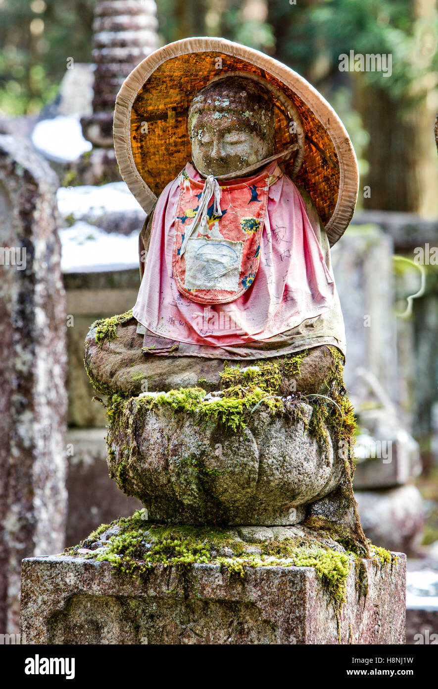 Le Japon, l'ancien cimetière Okunoin, Koyasan. Petit coin de pierre-Jizo bosatsu statue bouddhiste avec soumission rouge et chapeau de paille conique. HDR. Banque D'Images