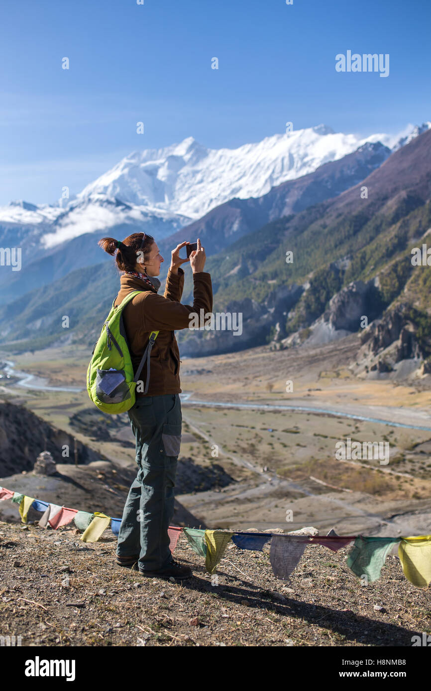 Woman photographing paysage sur téléphone mobile pendant le circuit de l'Annapurna trek dans l'himalaya, Népal Banque D'Images
