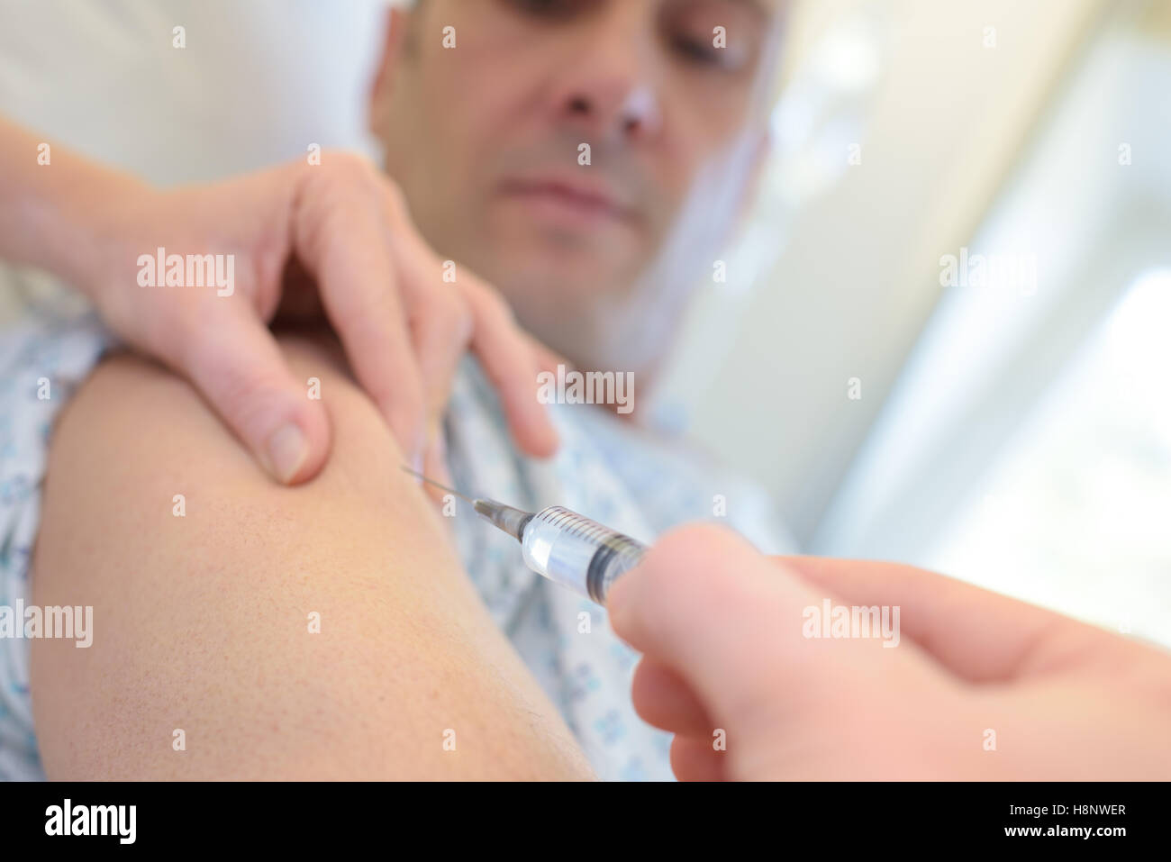 Médecin met la seringue dans le bras masculin Banque D'Images