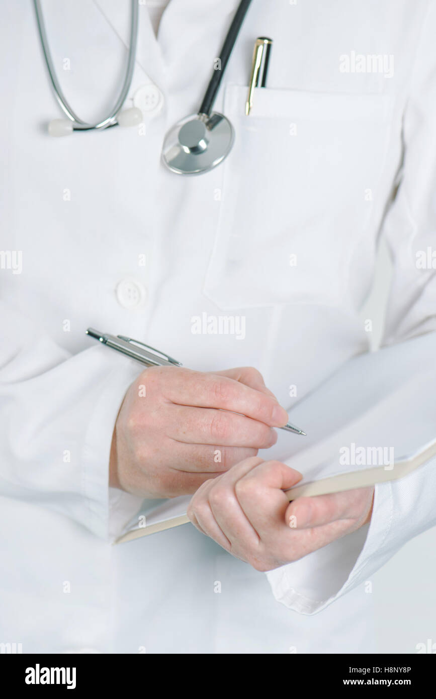 Female doctor writing on clipboard notepad papier vierge conseils médicaux, avertissement, recommandation ou suggestion. Banque D'Images