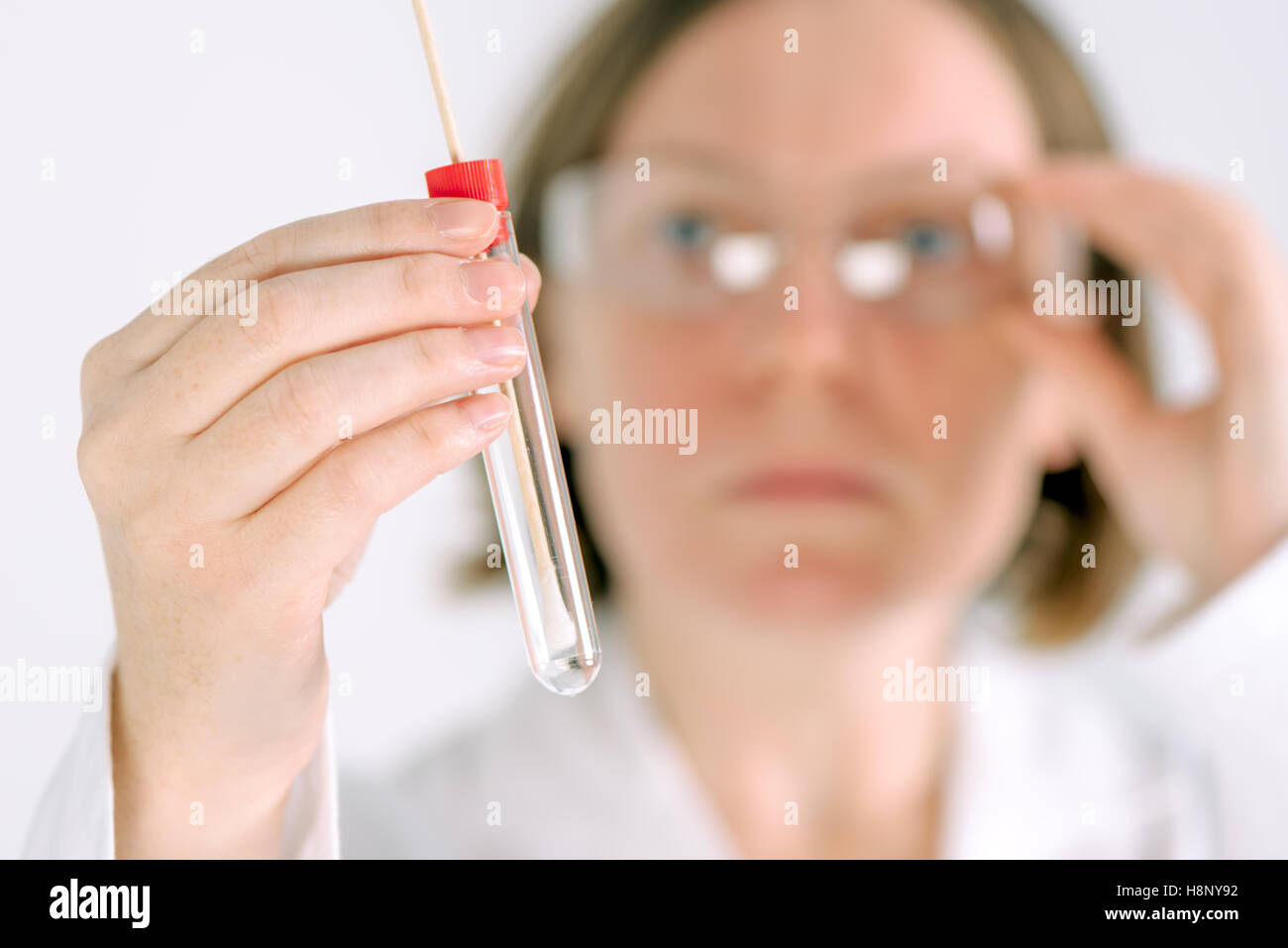 Femme gynécologue holding échantillon cervical jetables-tige et tube à essai dans le bureau de l'hôpital, prêt à l'ex médical gynécologique Banque D'Images
