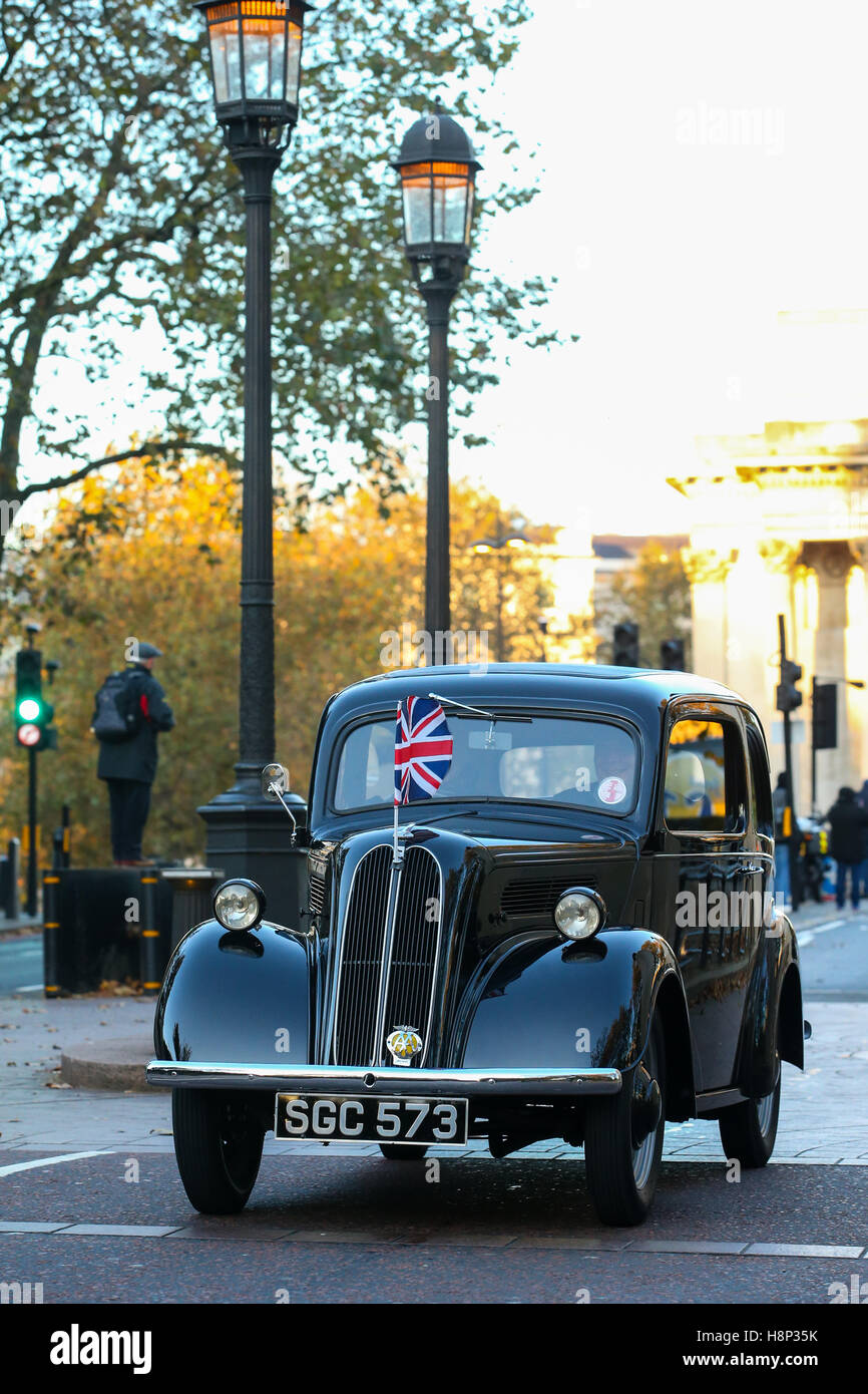 Un portrait d'une image couleur black 1955 lecteurs populaires Ford grâce à une rue de Londres avec union jack flag sur le capot Banque D'Images