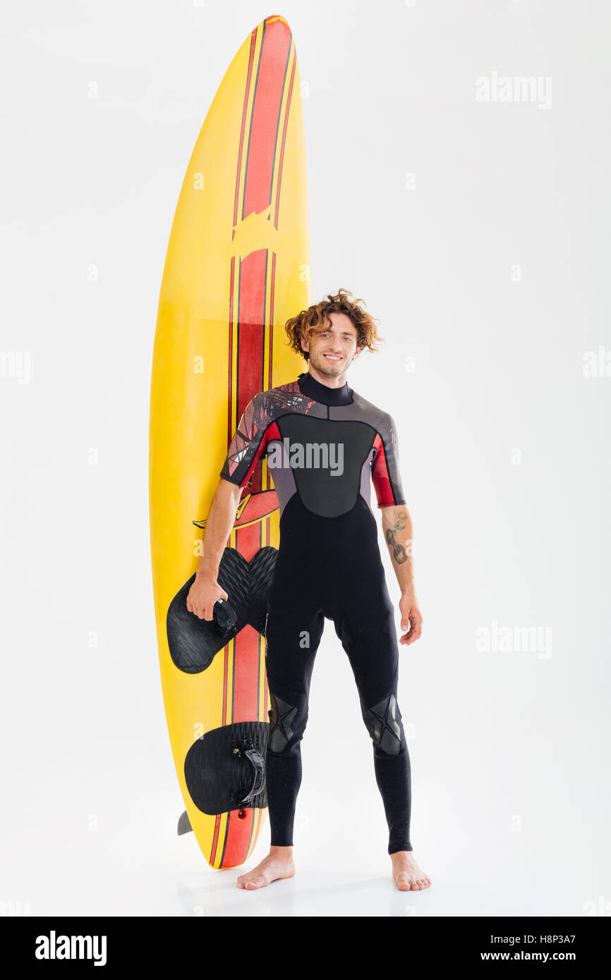 Portrait d'un jeune surfeur surf board holding heureux isolé sur fond blanc Banque D'Images