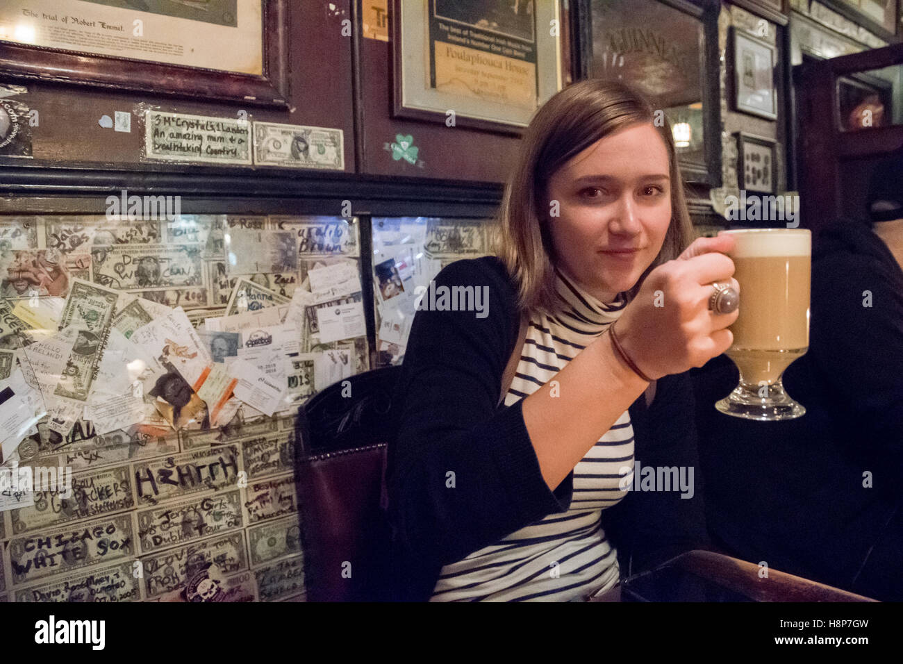 Dublin, Irlande- Jeune femme tenant un verre dans un pub de la ville de Dublin, la capitale de la République d'Irlande. Banque D'Images