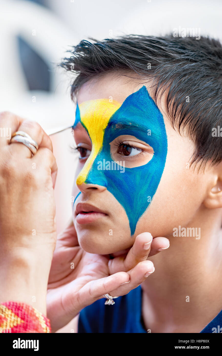 Beau garçon de neuf ans les jeunes enfants ayant son visage peint pour le plaisir à un anniversaire Banque D'Images