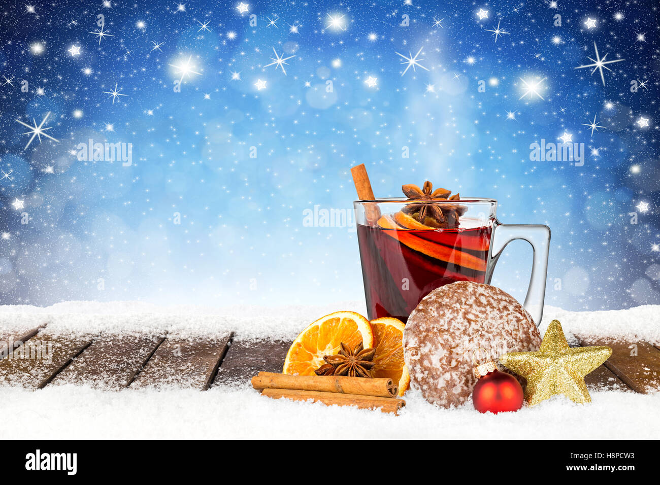 Vin chaud épicé chaud sur des bandes de neige en face de bleu ciel de nuit avec des étoiles et des flocons de contexte Banque D'Images