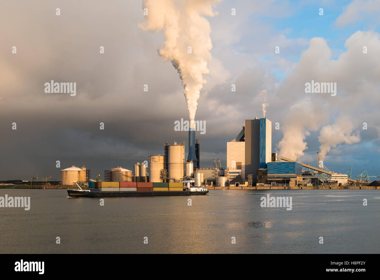 La fumée de l'industrie lourde est mis en lumière par le soleil. Tourné dans le domaine de l'industrie aux Pays-Bas l'Europoort de Rotterdam. Banque D'Images