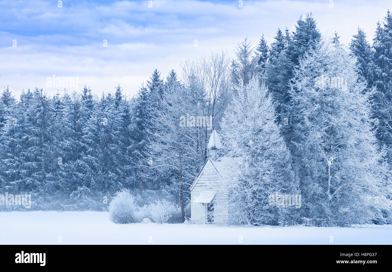 Paysage d'hiver serein idyllique avec snowy frosty forest et snowbound petite chapelle de woody sur névé Banque D'Images