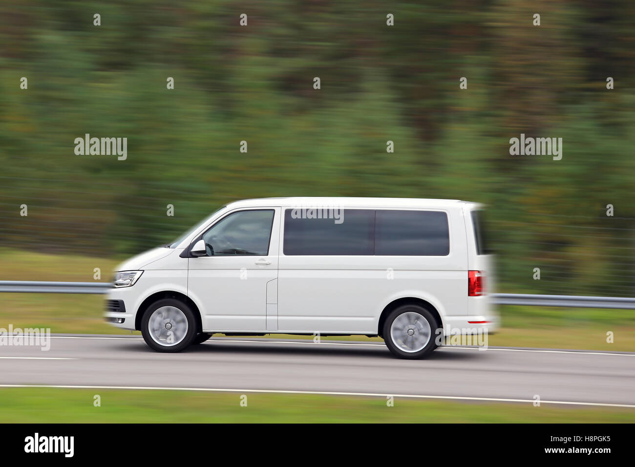 Blanc livraison van à vitesse élevée sur autoroute, vue de côté, la nature de fond vert floue. Banque D'Images