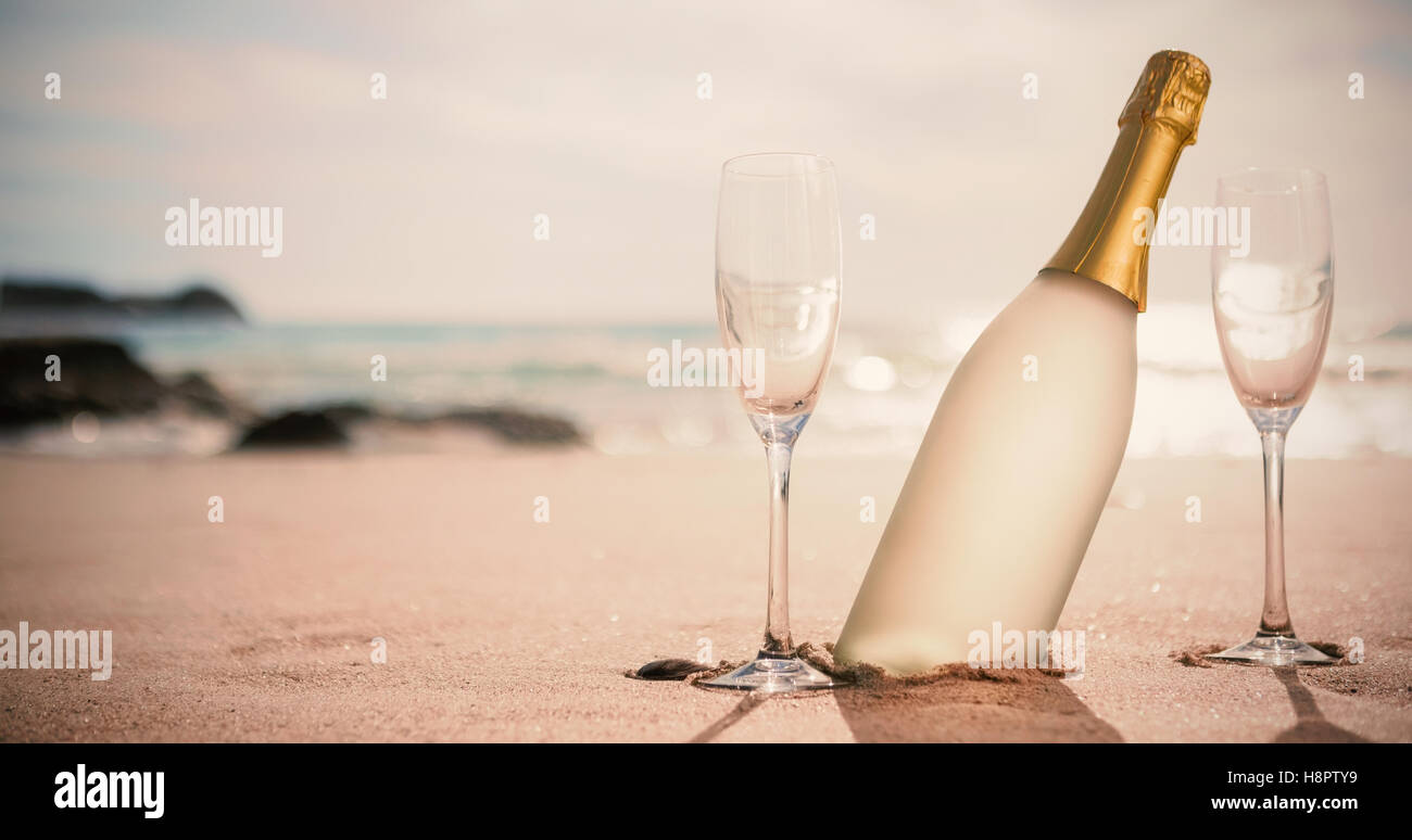 Bouteille de champagne et deux verres sur le sable Banque D'Images