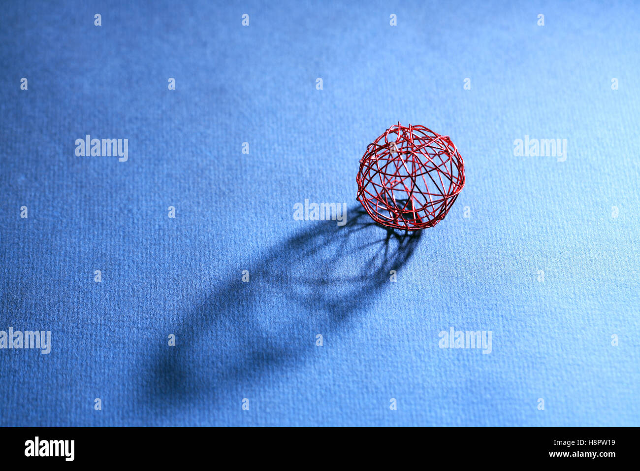 Une balle faite à partir de fil rouge à l'ombre sur fond sombre Banque D'Images
