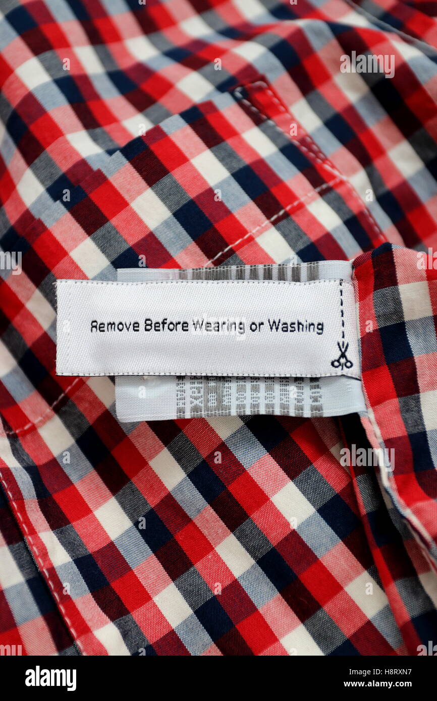 'Enlever avant de porter et lave-' tag RFID sur chemise à carreaux rouge Banque D'Images