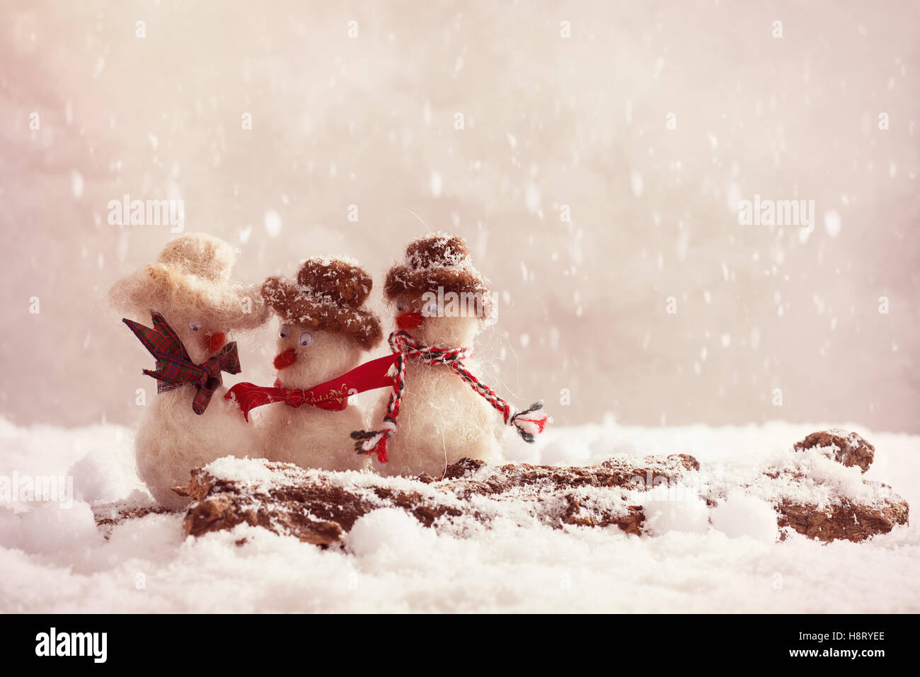 Les bonshommes ayant un gossip sur un journal couvert de neige Banque D'Images