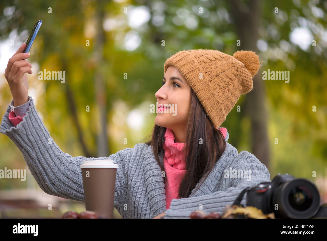 Technologie Internet et de bonheur concept. Femme heureuse girl taking self photo smartphone selfies avec appareil photo à l'extérieur à l'automne Banque D'Images