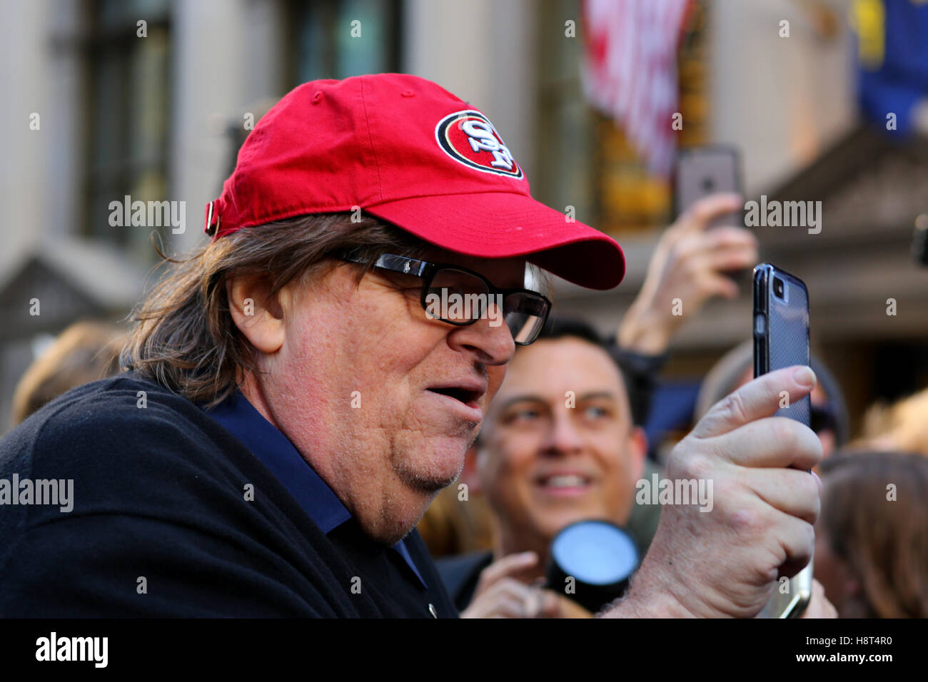 Michael Moore documentant une manifestation avec un smartphone Banque D'Images