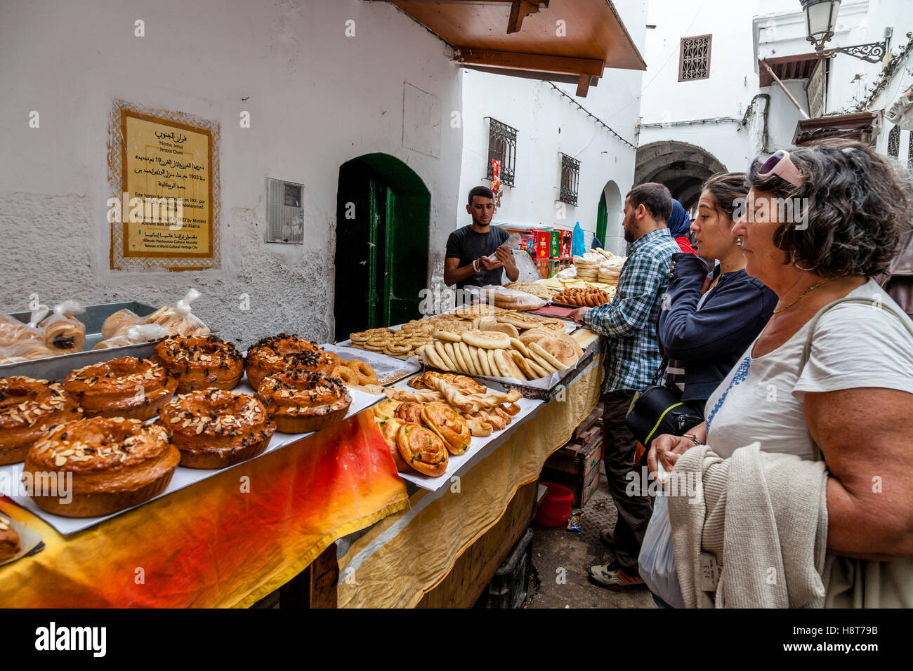 La population locale et les touristes la queue pour acheter du pain et viennoiseries d'une boulangerie dans la médina, Tétouan, Maroc Banque D'Images
