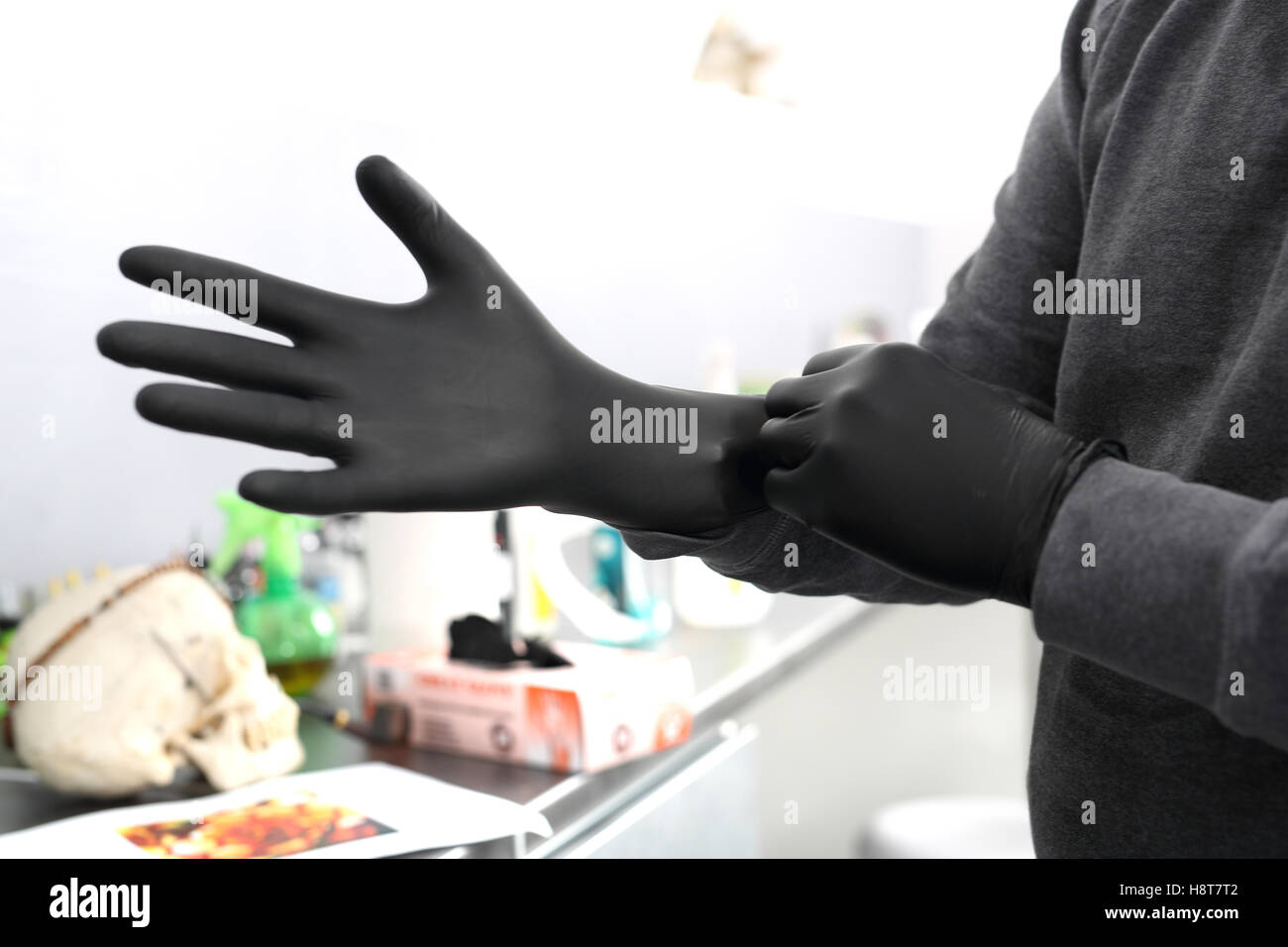 Homme tatoueur suppose des gants en latex noir Banque D'Images