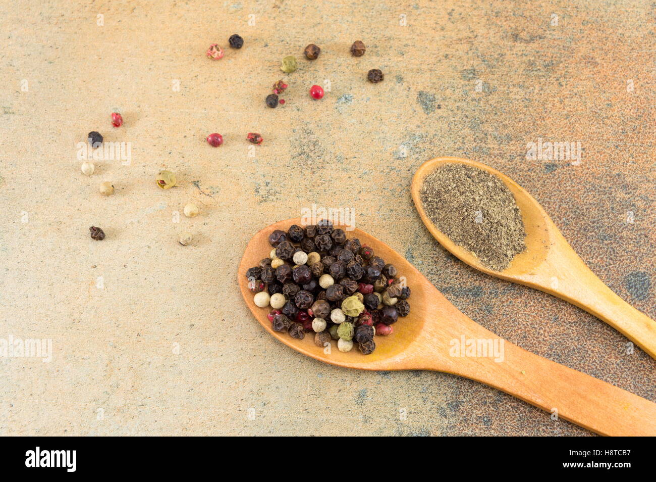 Boules de poivre rouge et brun et poudre sur table en pierre Banque D'Images