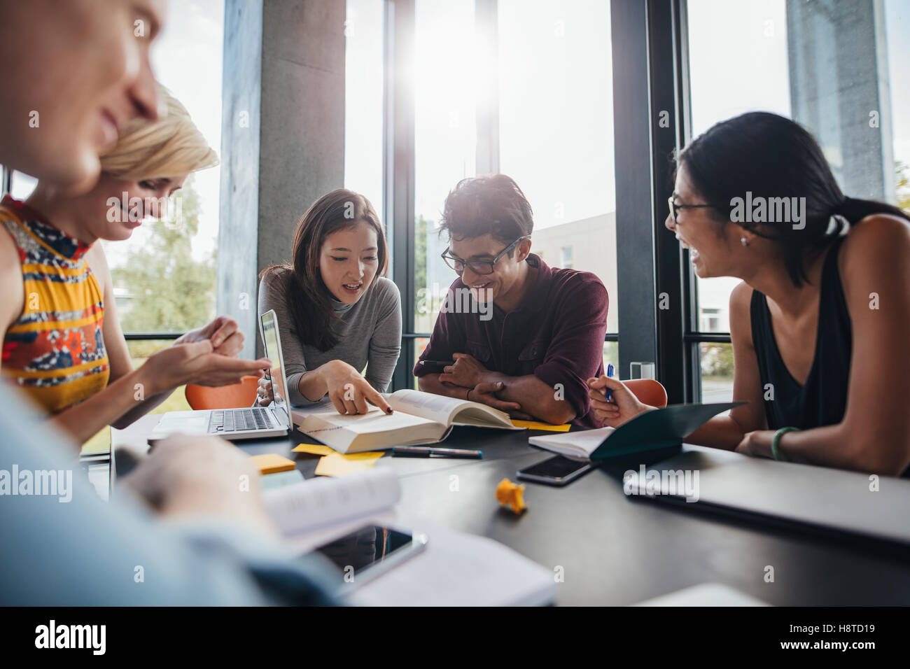 Jeunes étudiants assis à une table dans une bibliothèque et lisant des livres pour leur devoir de classe. étudiants universitaires faisant le groupe stu Banque D'Images