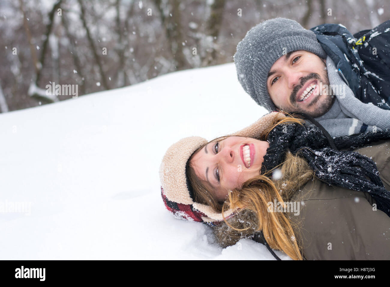 Smiling mature couple dans un parc couvert de neige Banque D'Images