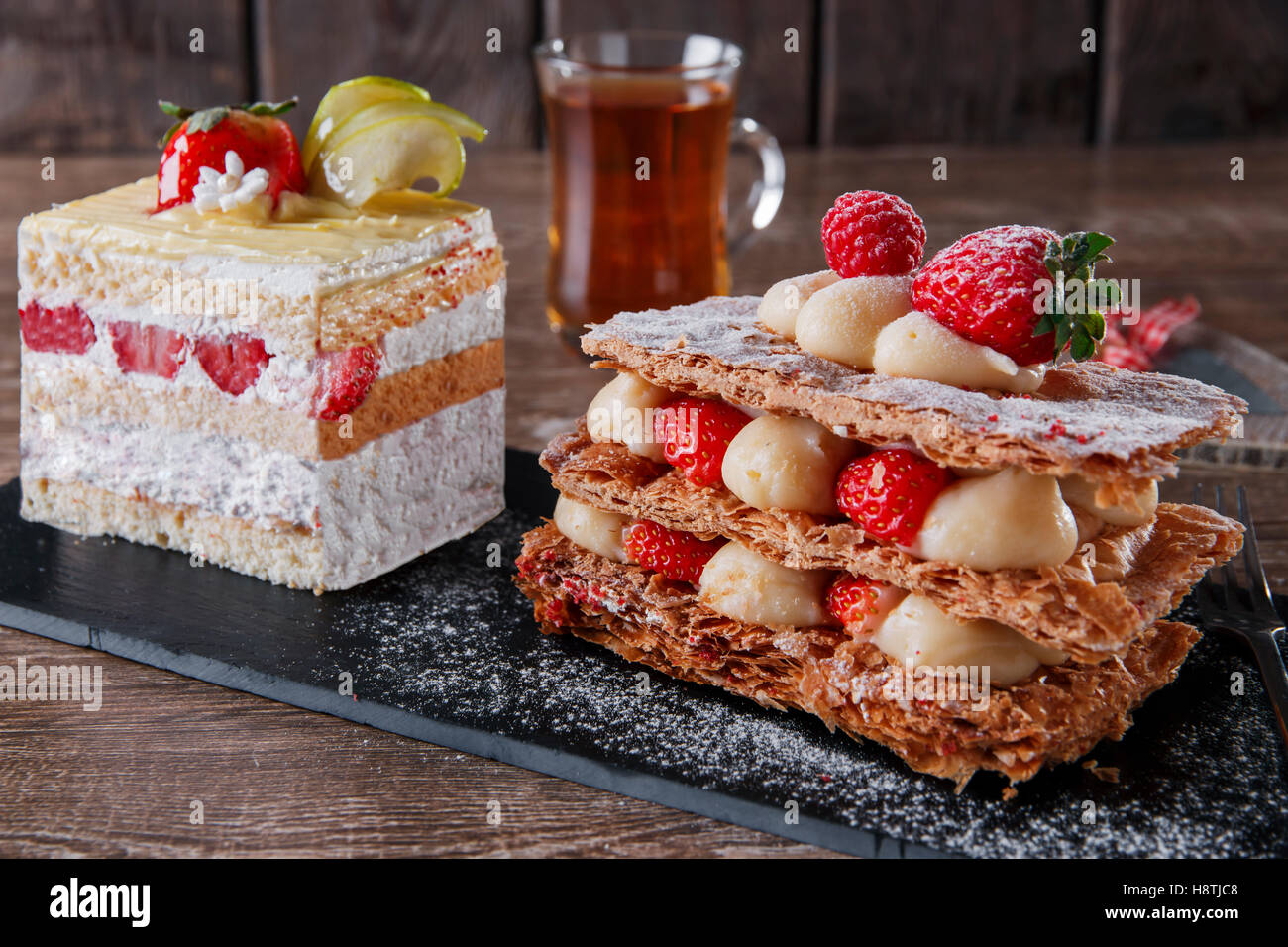 Fraises Crème mille feuille glaçage sucré dessert sur pierre noire Banque D'Images