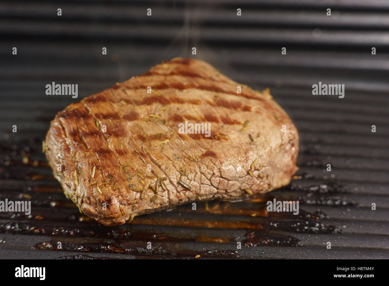 Un steak de boeuf à rôtir sur le gril Banque D'Images