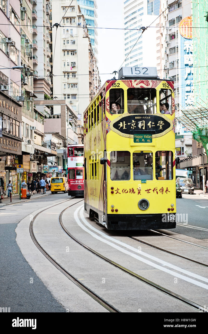 Ding Ding rue voiture jaune à venir autour d'un coude à Central, Hong Kong Banque D'Images