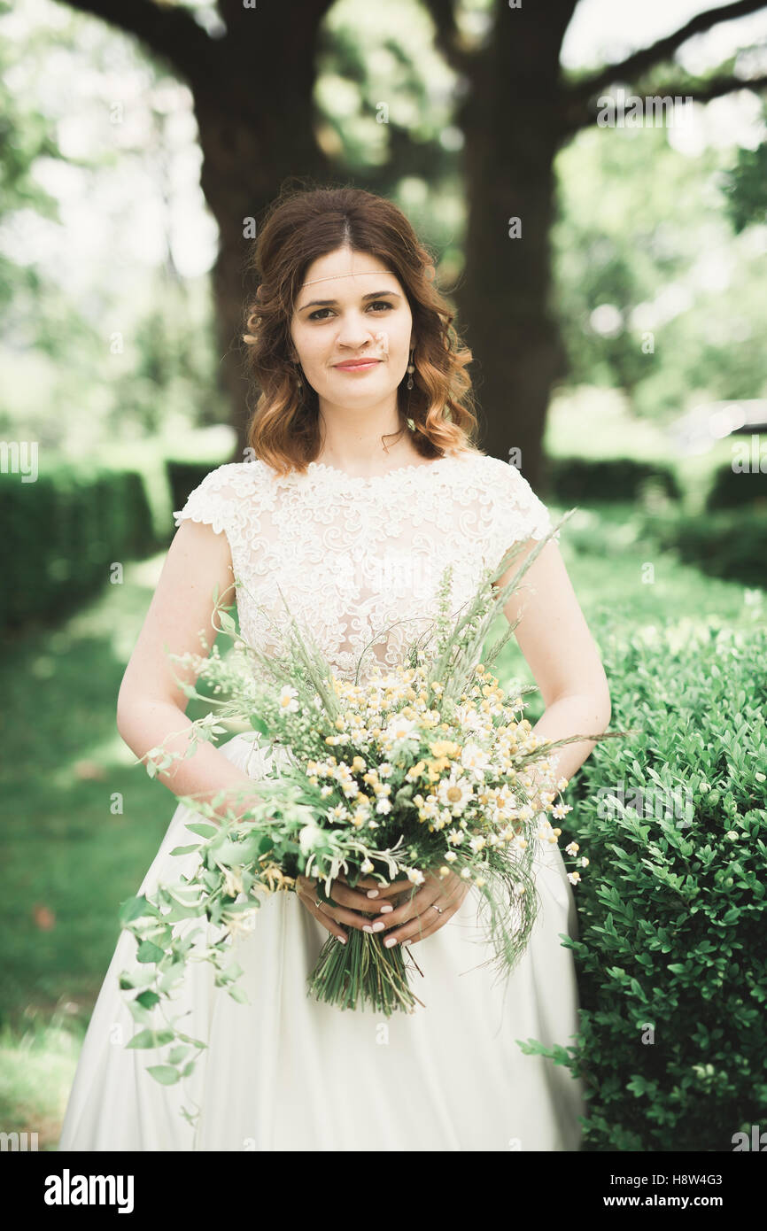 La bride holding bouquet de fleurs dans le parc. Wedding Banque D'Images