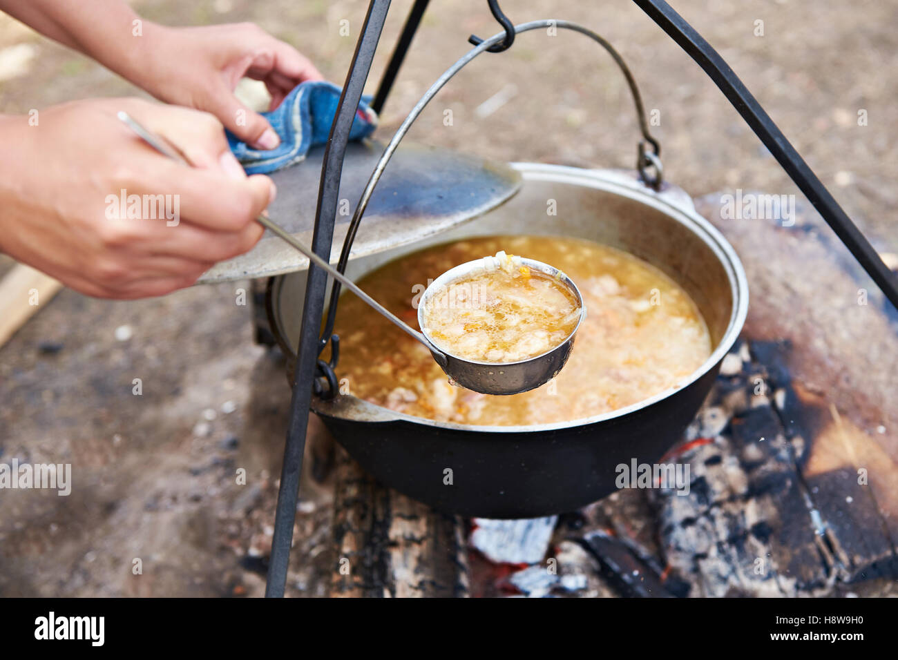 Cuisson de la soupe de la nourriture sur un feu de camp dans une randonnée Banque D'Images