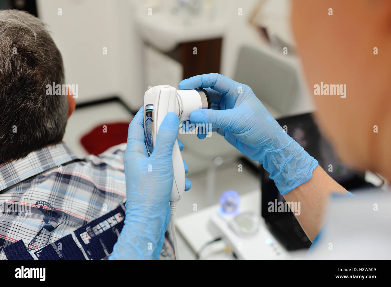 Diagnostics cheveux et le cuir chevelu. Trihoskopiya. Médecin patient examiner un appareil spécial cheveux hommes Banque D'Images