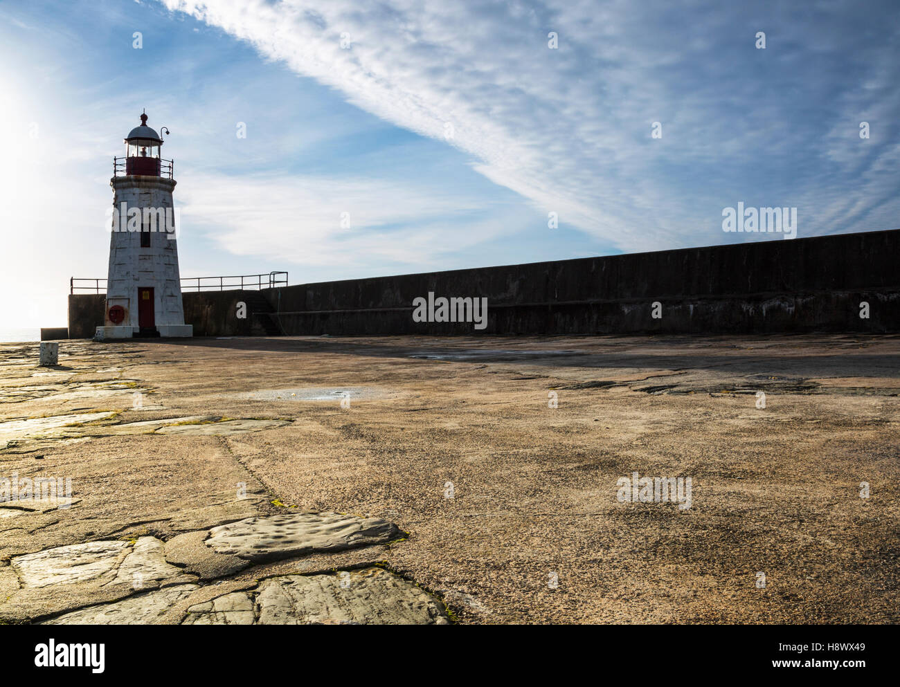 Phare du port de Cuba avec le soleil derrière à côté du mur du port. Banque D'Images