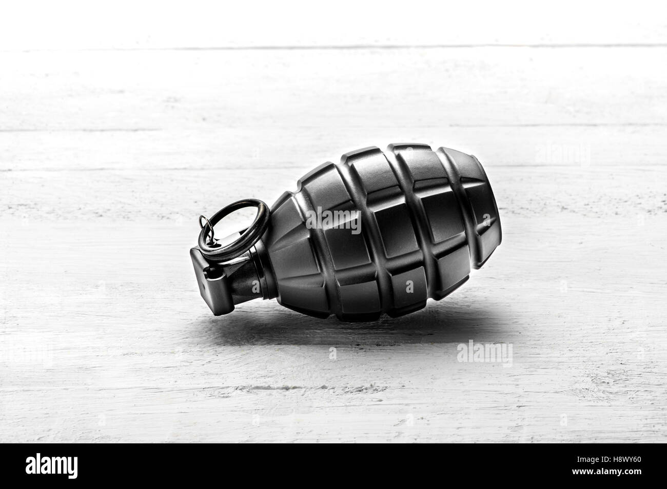 Grenade à main avec l'axe de couché sur le côté, sur une planche de bois blanc centré avec copie espace Banque D'Images