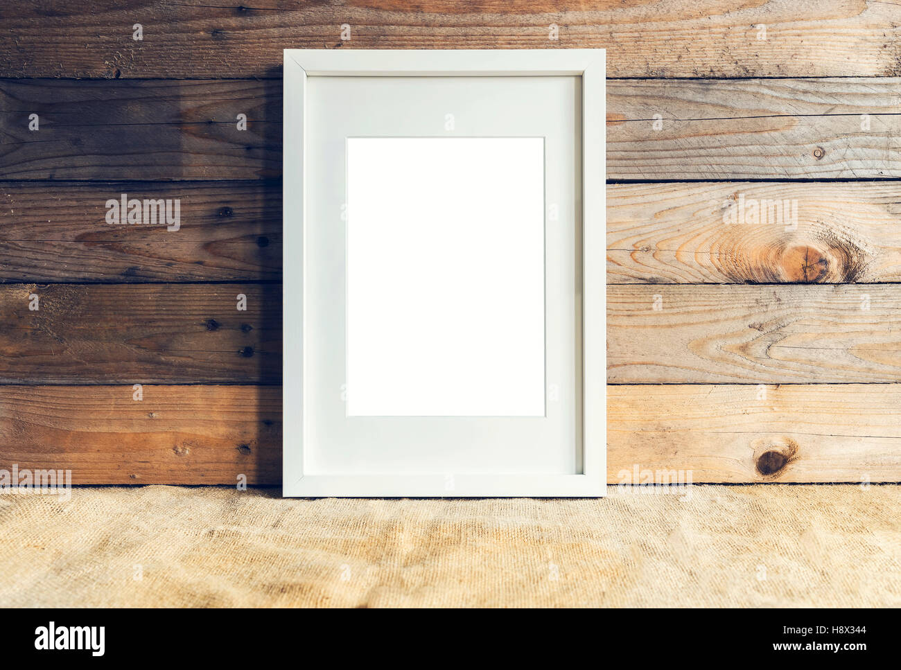 Image de cadre vide, blanc sur fond de bois. Vue de face. Banque D'Images