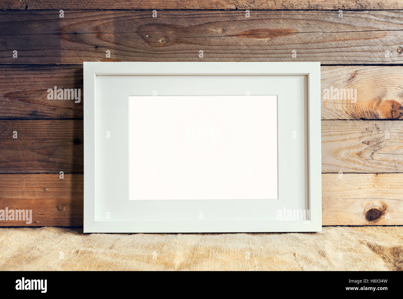 Image de l'article blanc châssis maquette sur fond de bois avec de la toile de jute. Banque D'Images