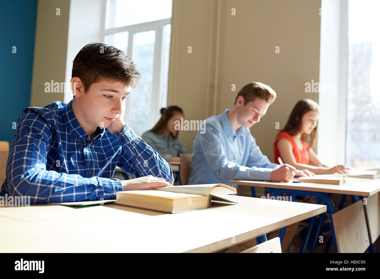 Groupe d'étudiants avec des livres scolaires d'écriture tester Banque D'Images