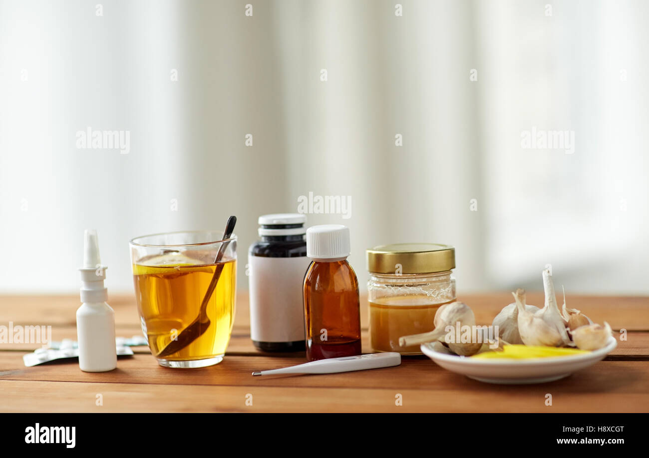 La drogue, thermomètre, le miel et une tasse de thé sur bois Banque D'Images