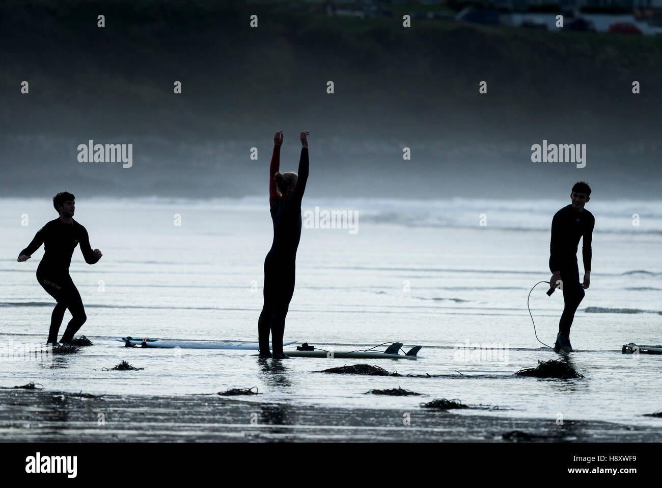 Trois surfeurs prépare à naviguer à dans Fistral Newquay, Cornwall. Banque D'Images