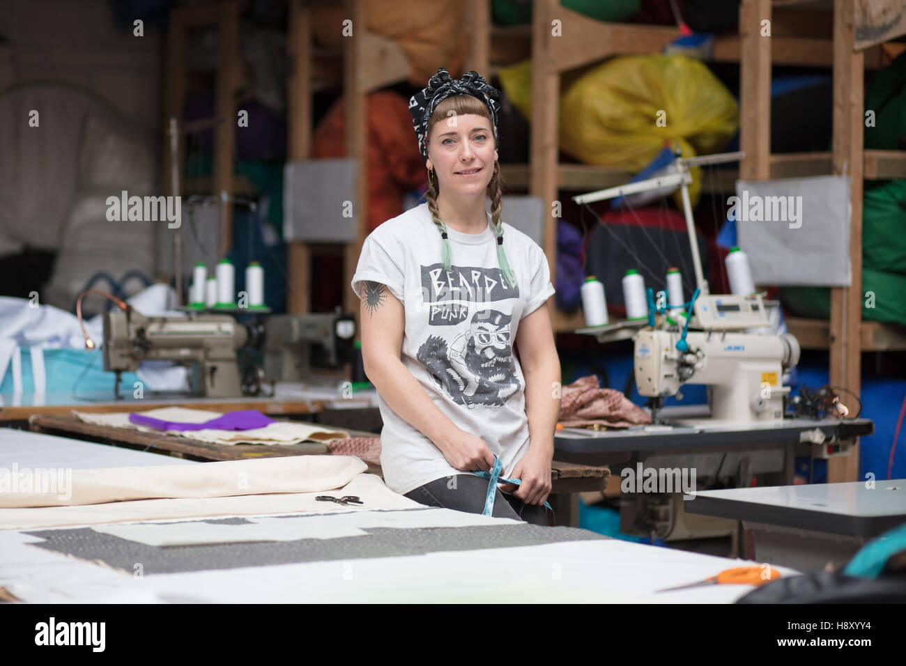 Portrait d'une jeune couturière tatouée dans un environnement d'usine Banque D'Images