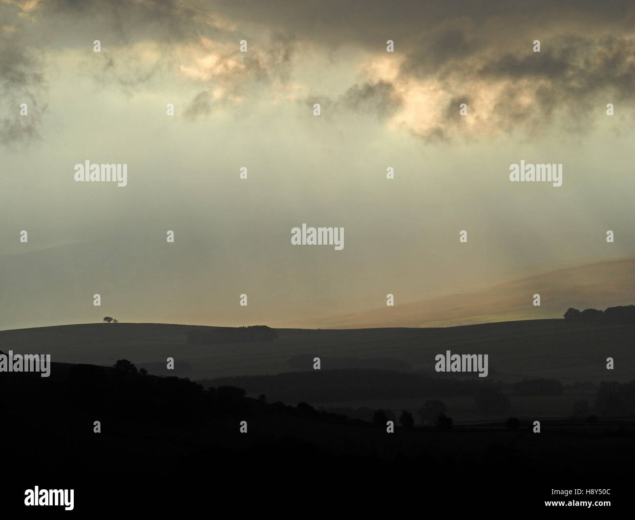 Moody golden morning light atmosphérique traversant des nuages sombres sur le recul de la Foothills England UK Cumbria Fells Cap Sud Banque D'Images
